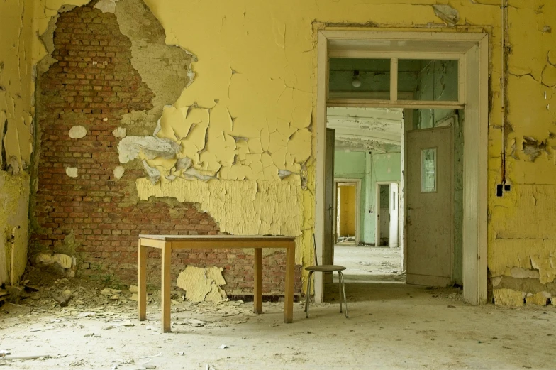 an old room with chipped walls and wooden tables