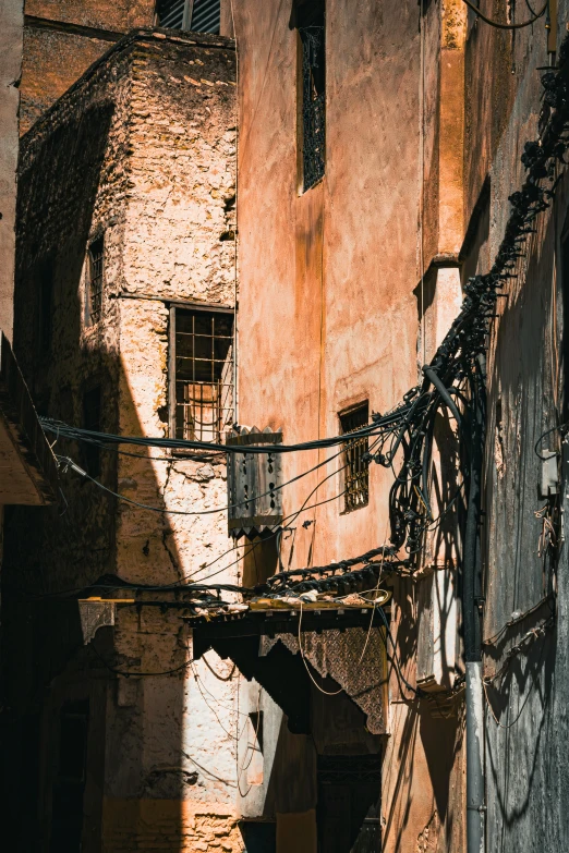 a narrow alley between two buildings and an electrical wire