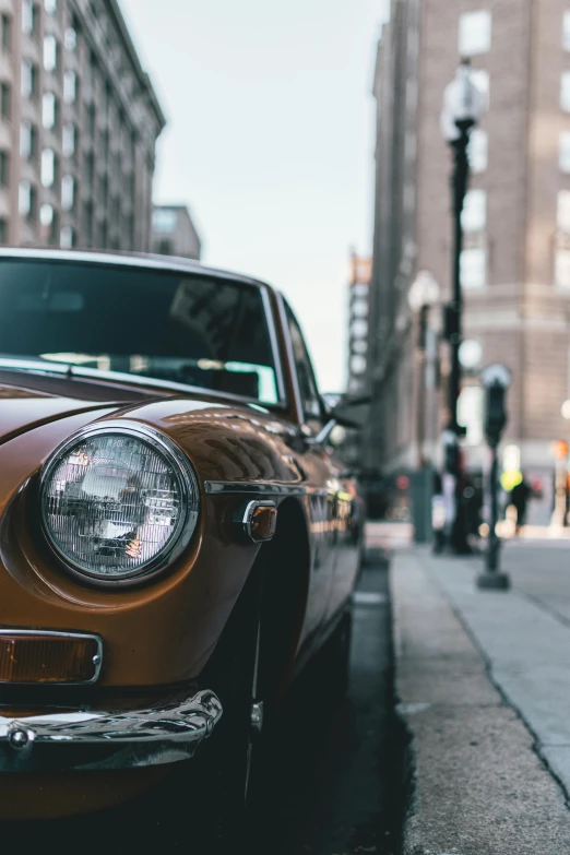 a brown vintage car is sitting in a crowded city street