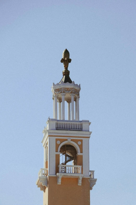 the bell tower of a building has a statue on top
