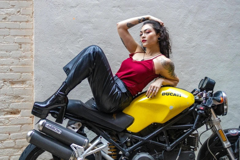 a woman sitting on the seat of a yellow motorcycle