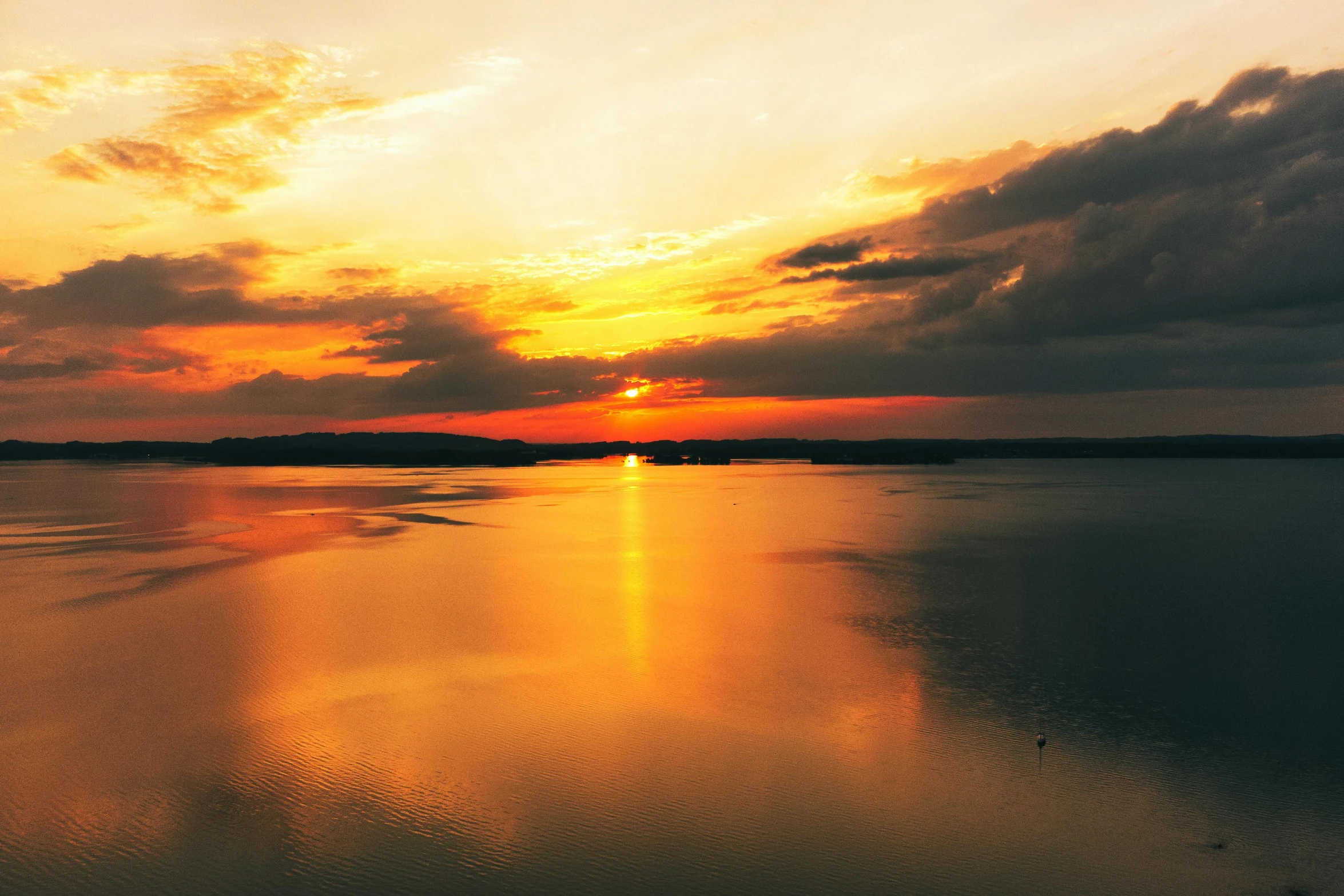 the sun rising over a body of water