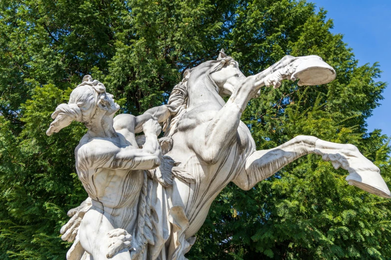 a statue depicting a man with a horse and two people surrounding him