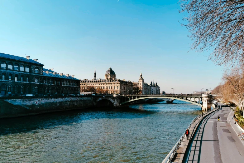 a long road going down a river by some buildings