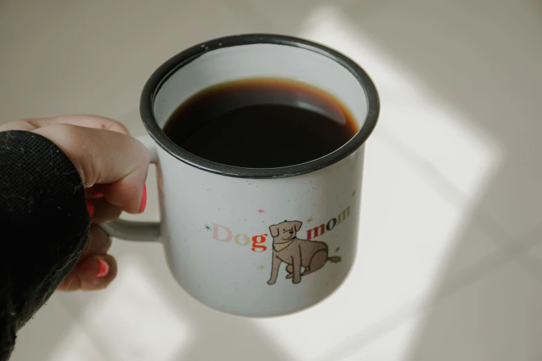 a person holding up a coffee cup with their hand