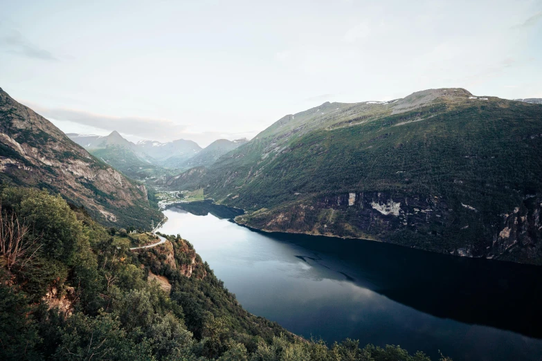 there is some water next to mountains with a river running through it