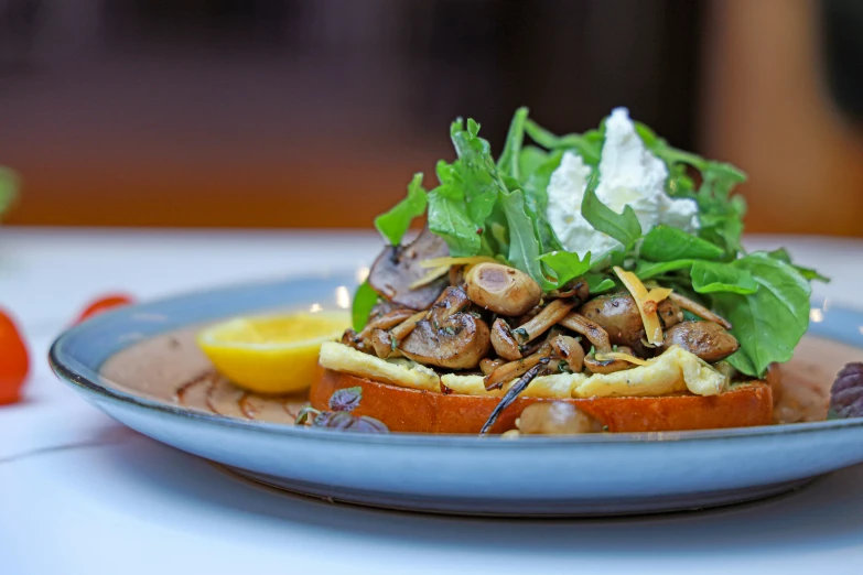 a blue plate topped with food covered in greens