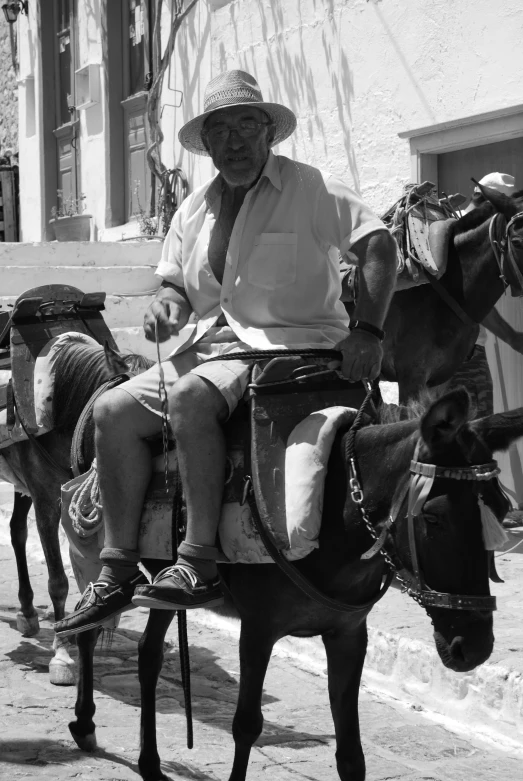 man riding a horse drawn carriage down the street