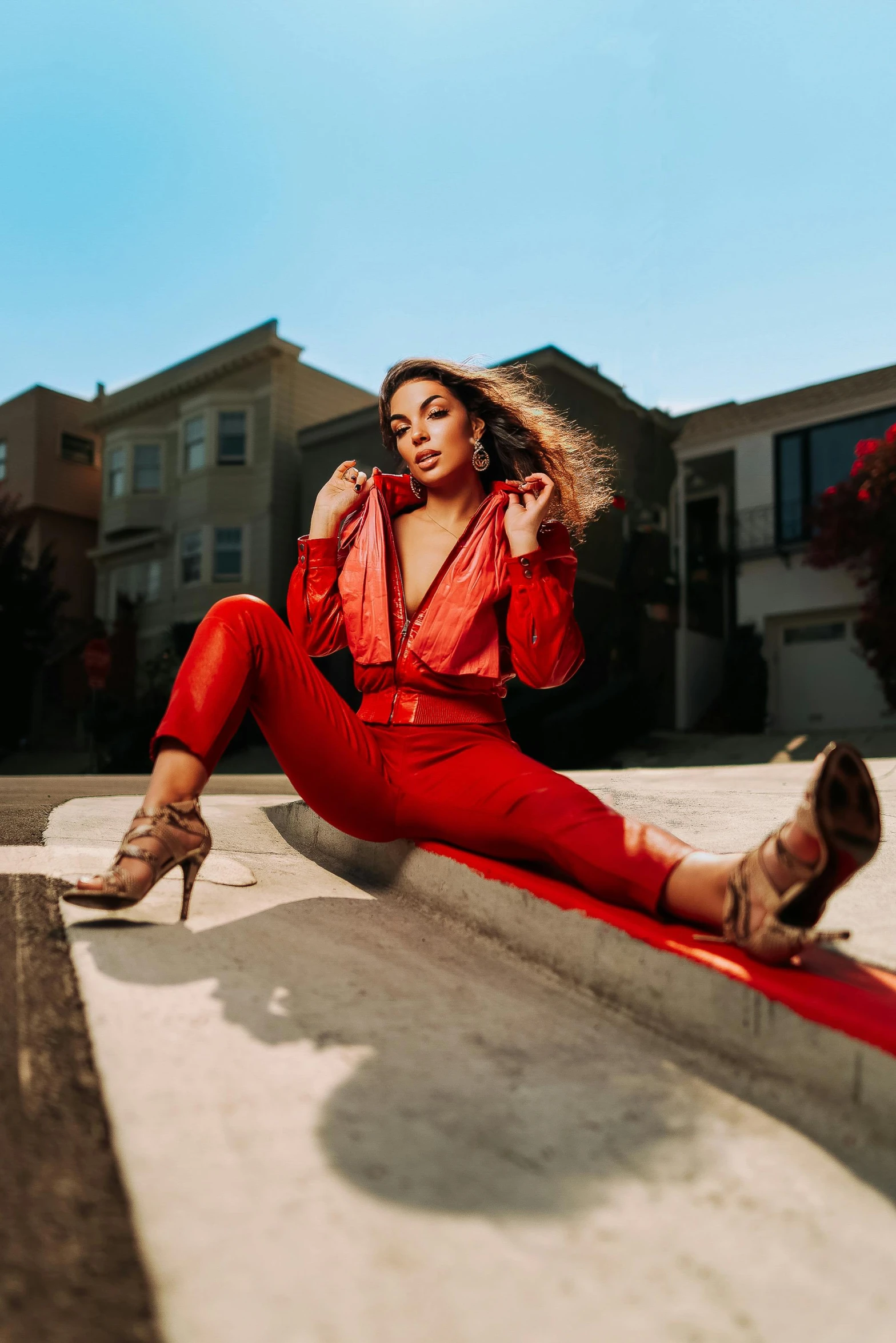 a woman sitting on top of a curb next to a street