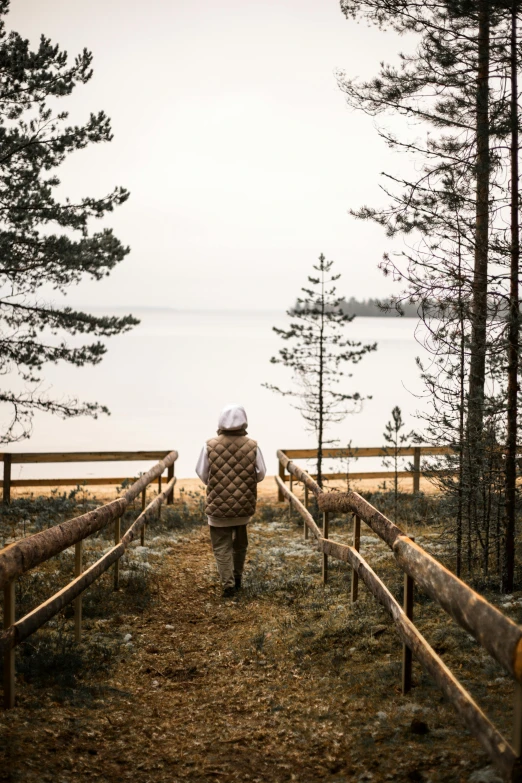 a woman walking in a wooded area near water