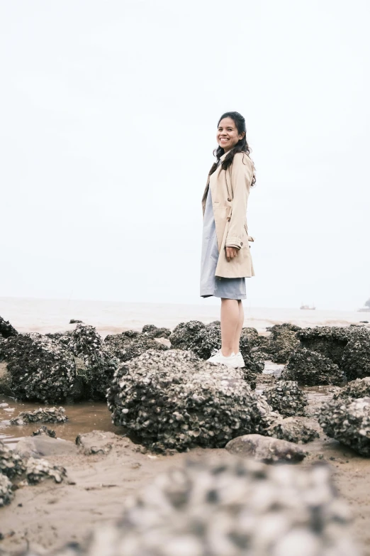 the woman is taking a picture while standing on some rocks