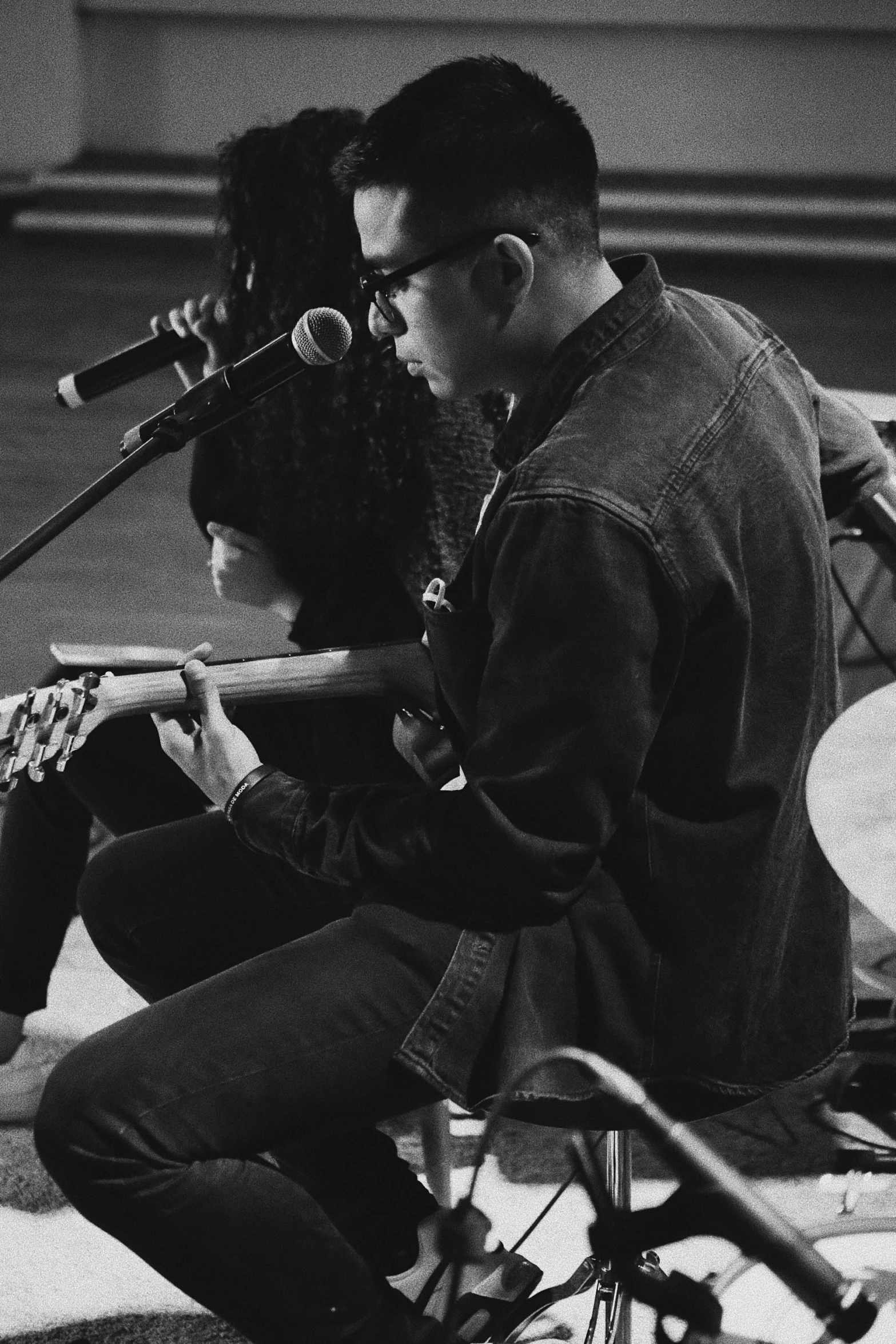 a woman holding a microphone near a man sitting on a bike