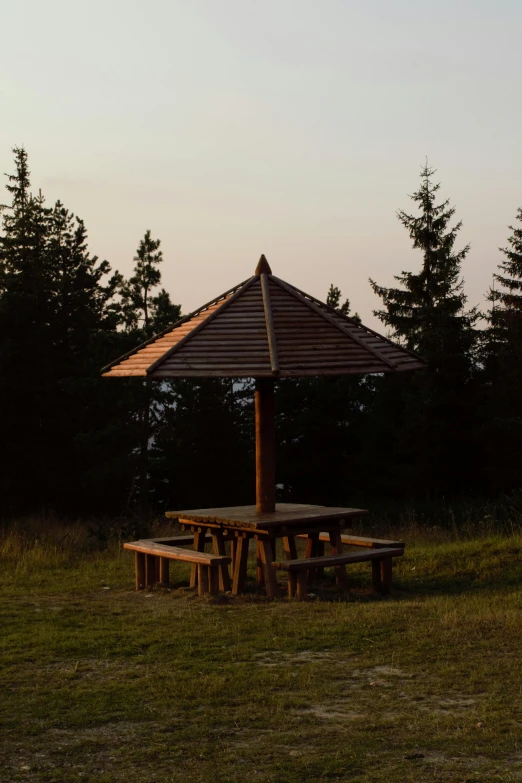 a wood table sitting under a wooden umbrella