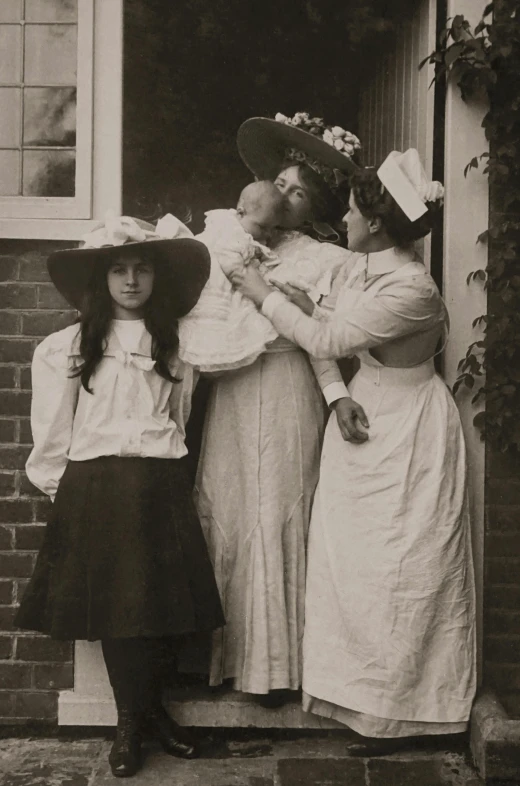 a vintage po of two woman in dress and hat hugging their children