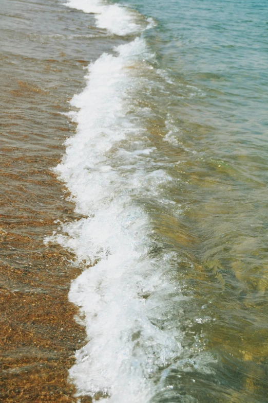 a couple of water waves crashing on to the beach