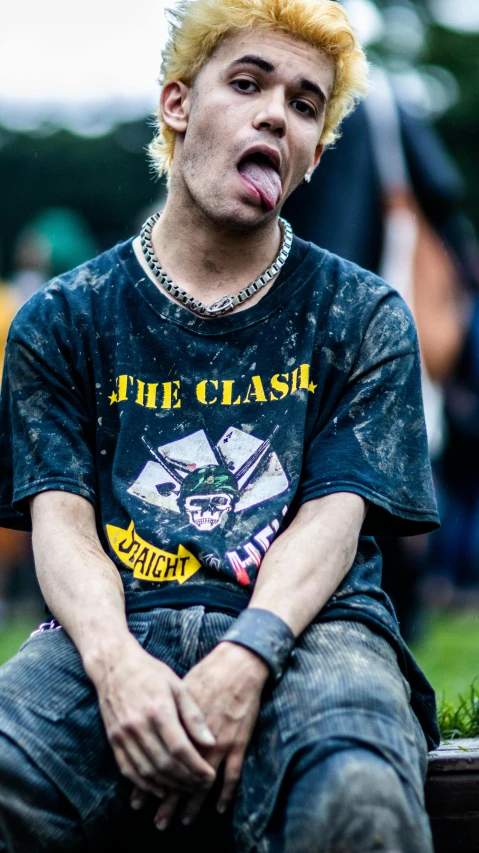 a male with a yellow hair sits and looks up at the camera