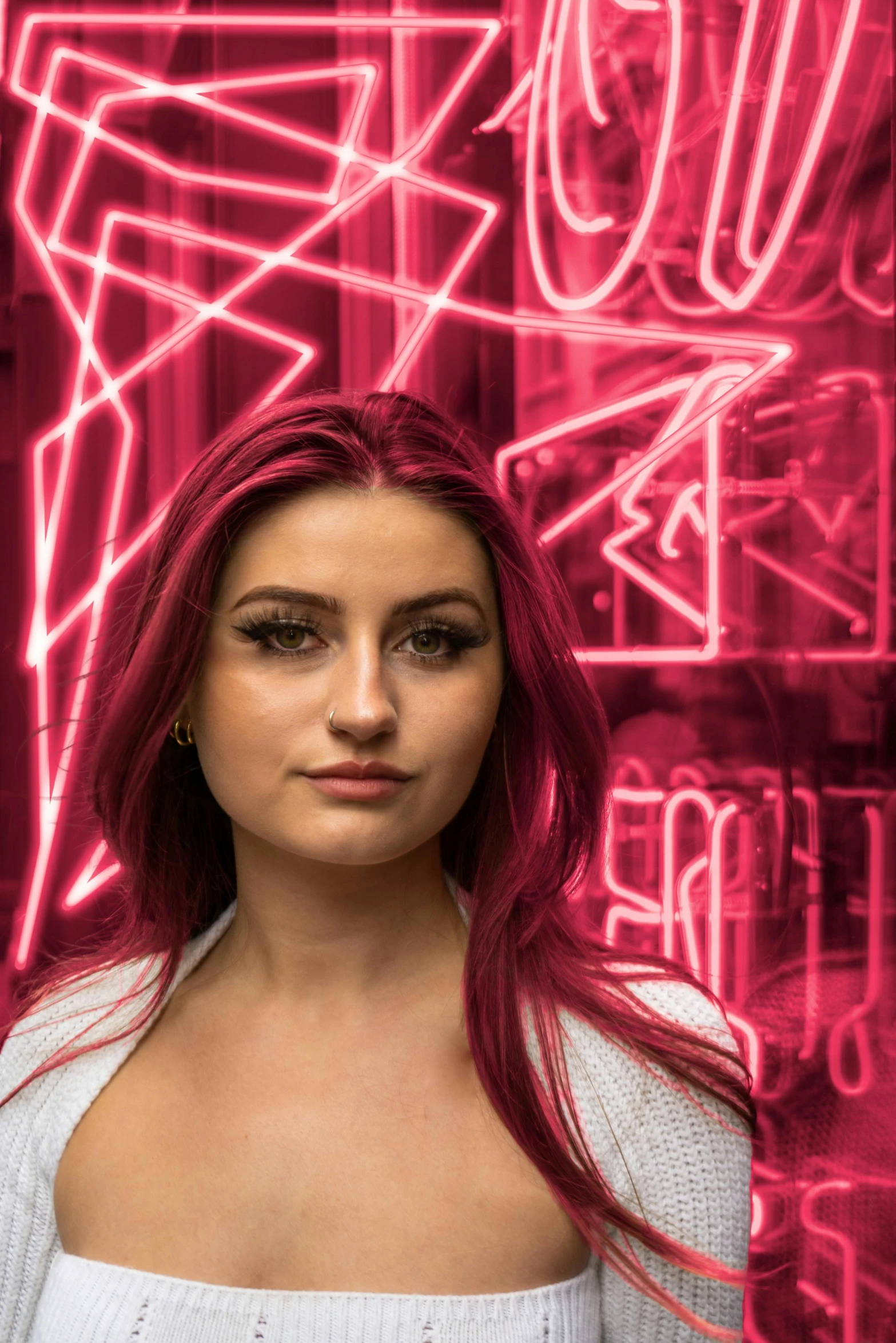 the girl is posing for a po in front of neon signs