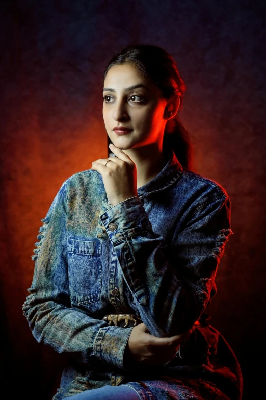 a young woman sitting and holding her hands together