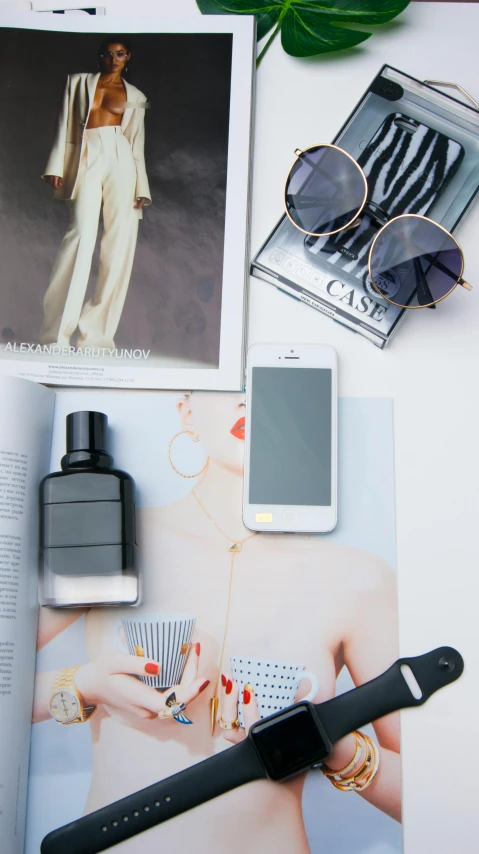 a display of clothes, accessories and phone on a white table