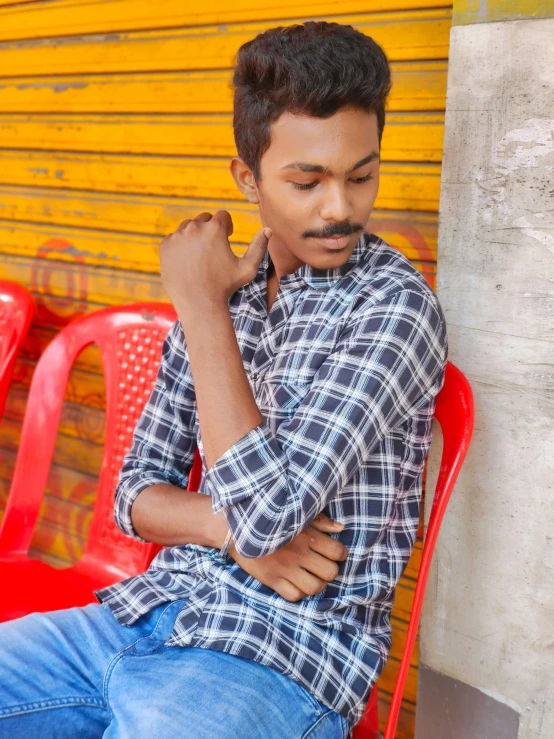 a person sitting in a chair leaning against a wall