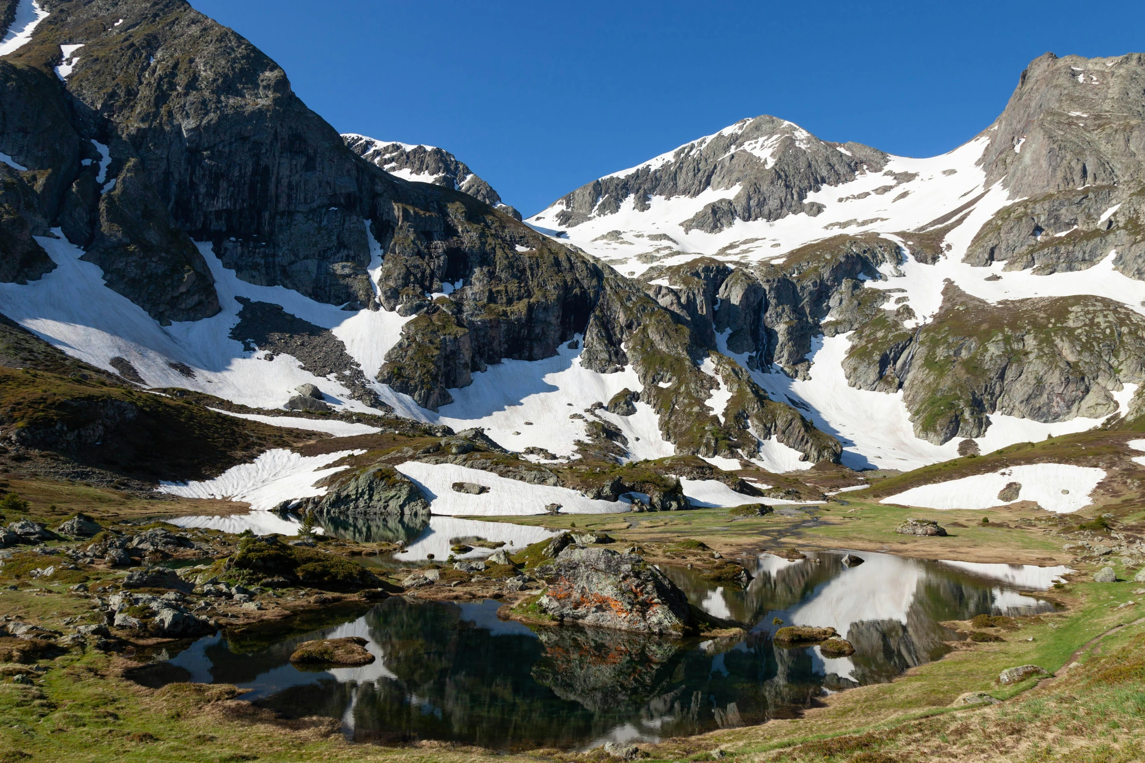 two mountains are shown with reflections of water in the water