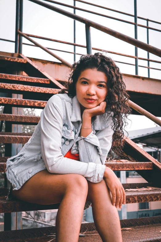 a woman sitting on a brown set of stairs