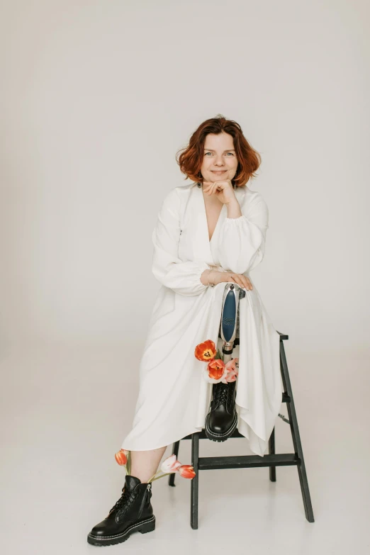 a woman in a white dress sitting on a chair