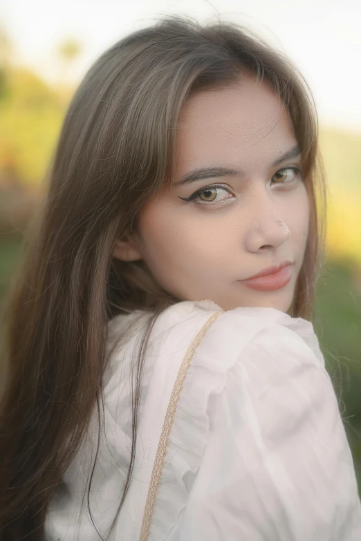 a beautiful young lady standing outside on a sunny day