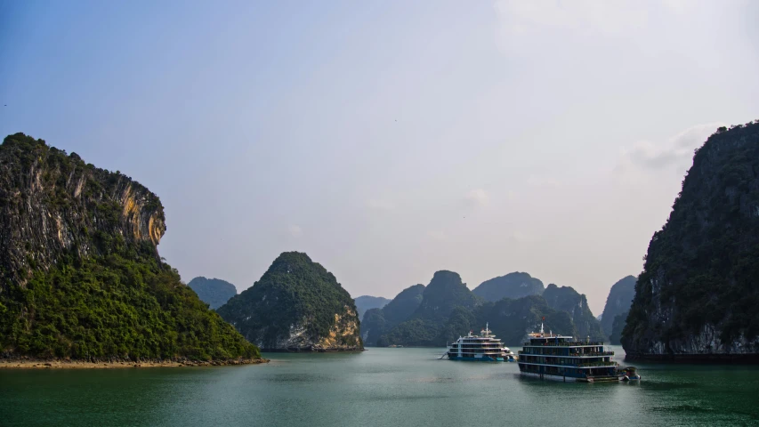 cruise ships in the water surrounded by large rock formations