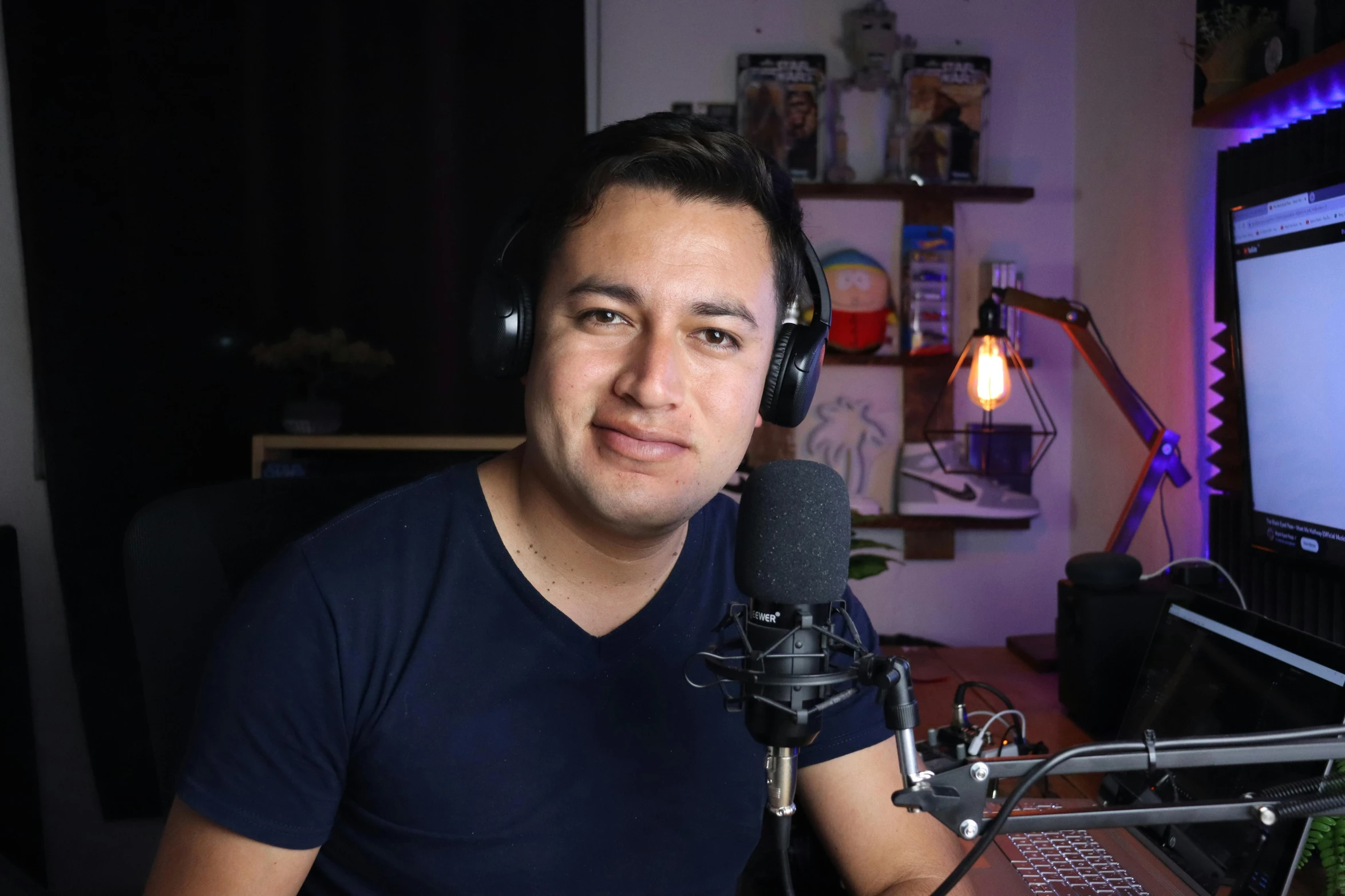 a man in a recording studio sitting in front of a microphone