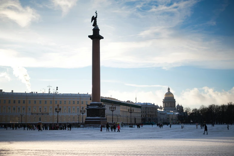 people walk along the frozen ground in front of a tall building