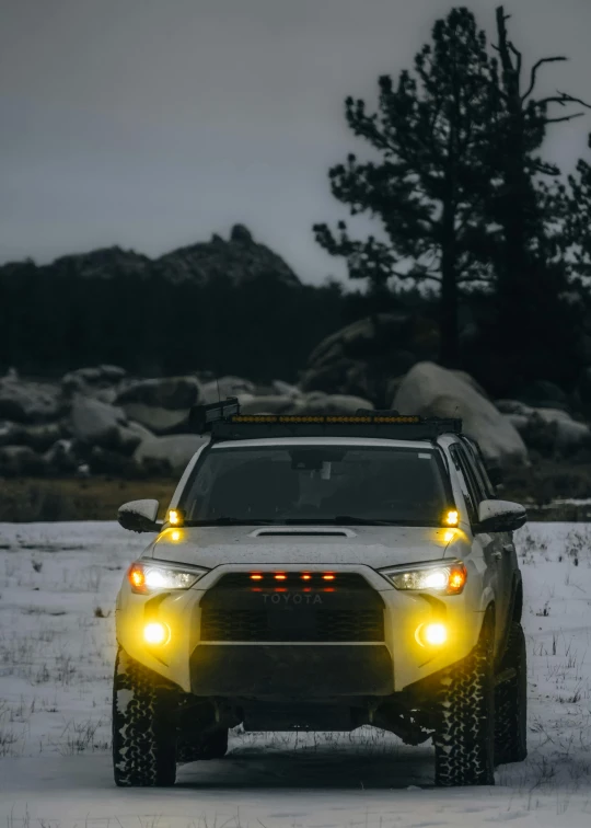 a white truck driving on snow covered ground