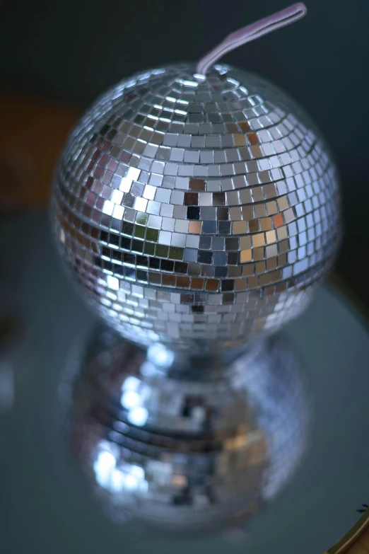 mirror ball and straw on table with reflection in it