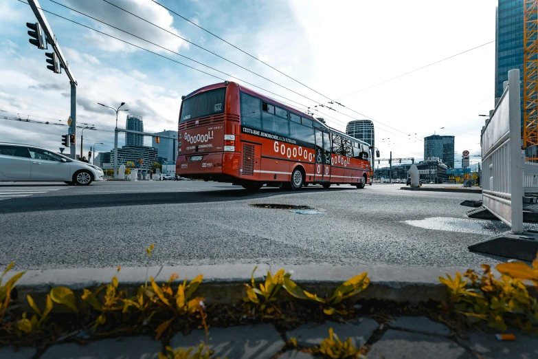 a red passenger bus driving down a street