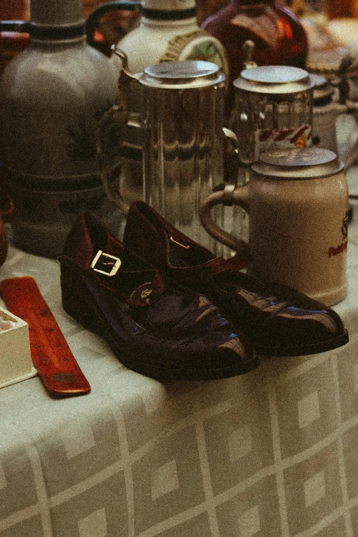 a pair of shoes sits on the table next to jars