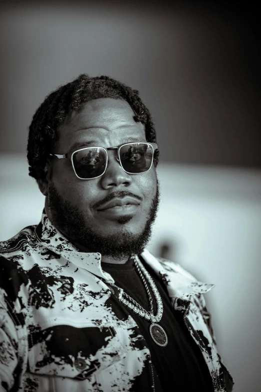 a young black man is wearing a flowery shirt and sunglasses