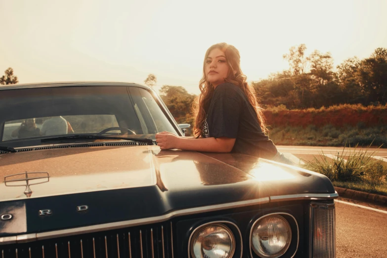 a girl is sitting on top of a parked car