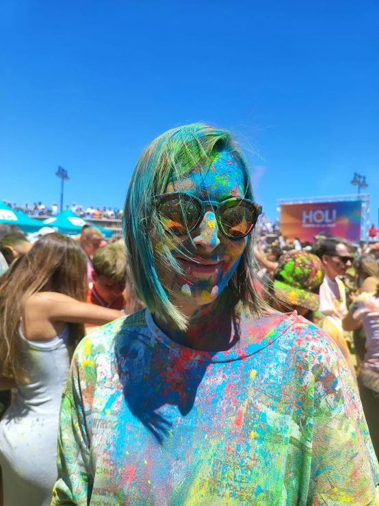 a woman with dyed hair and glasses standing in a crowd