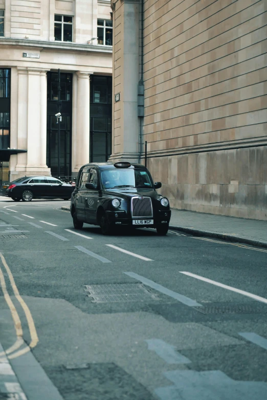 a street with a small car parked in front of a tall building