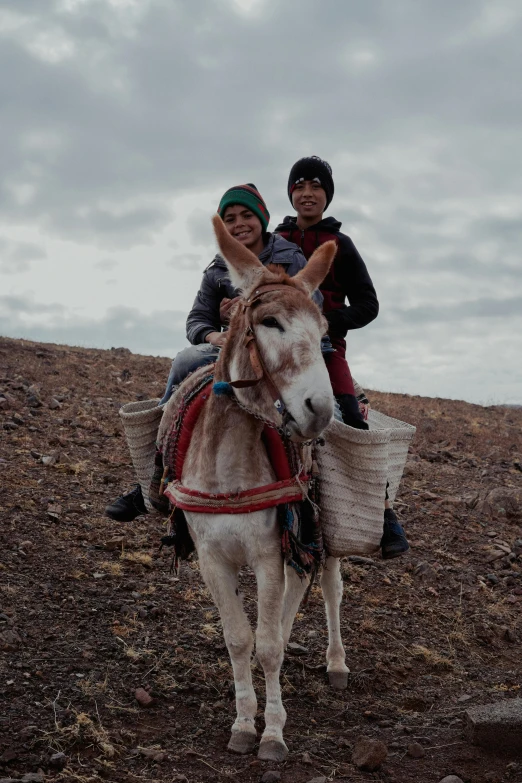 two people on a donkey on a hill