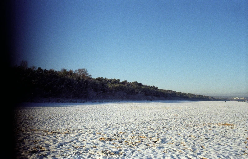 a snowy beach has only one person seen walking