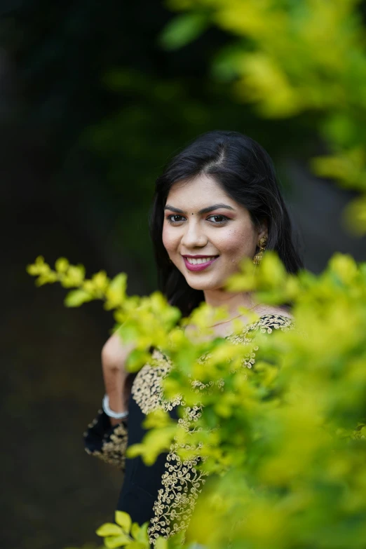 a woman standing in front of a tree posing for a po