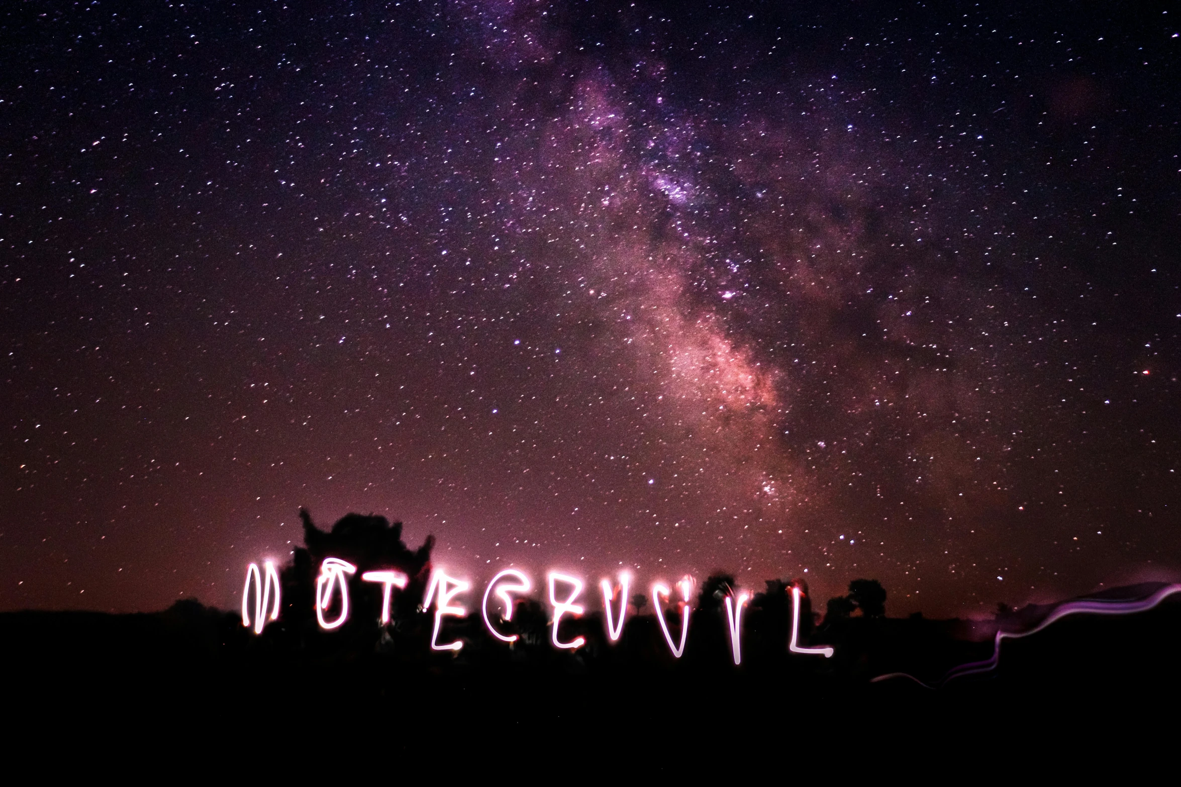 a view of a night sky with the words otdegevil lit up