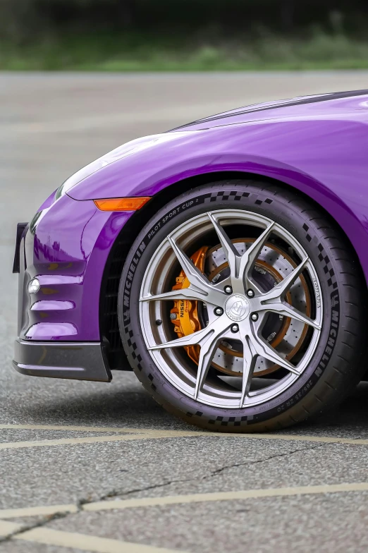 a close up view of a purple car with chrome wheels