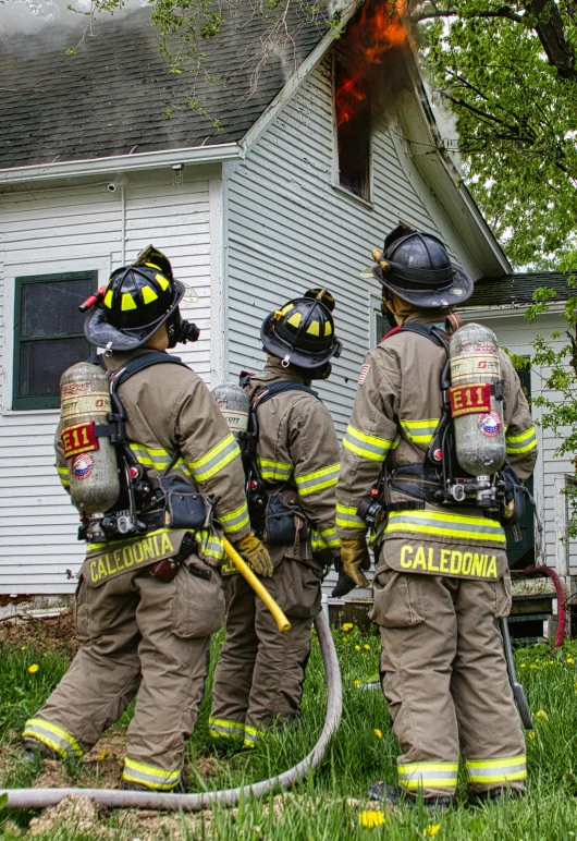 firemen with hoses in front of a house