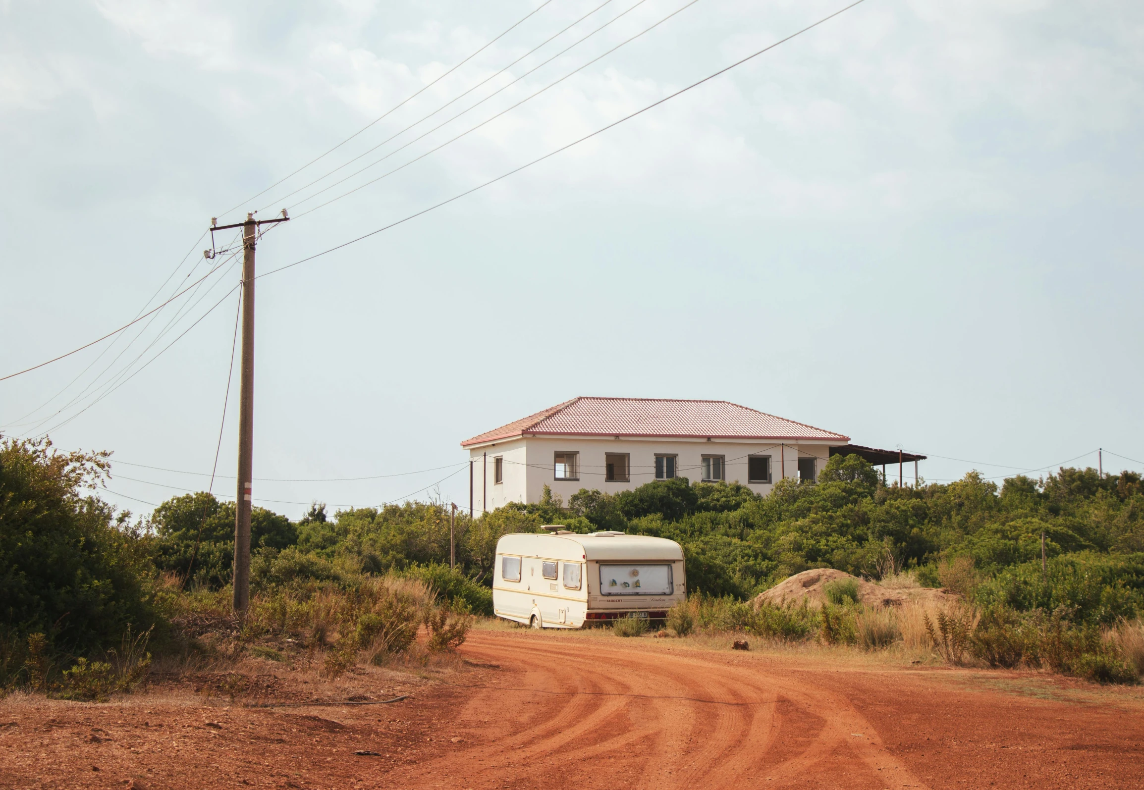 a car parked near a trailer on a dirt road