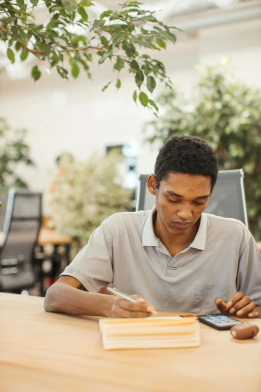 a man sitting at a desk, checking his phone