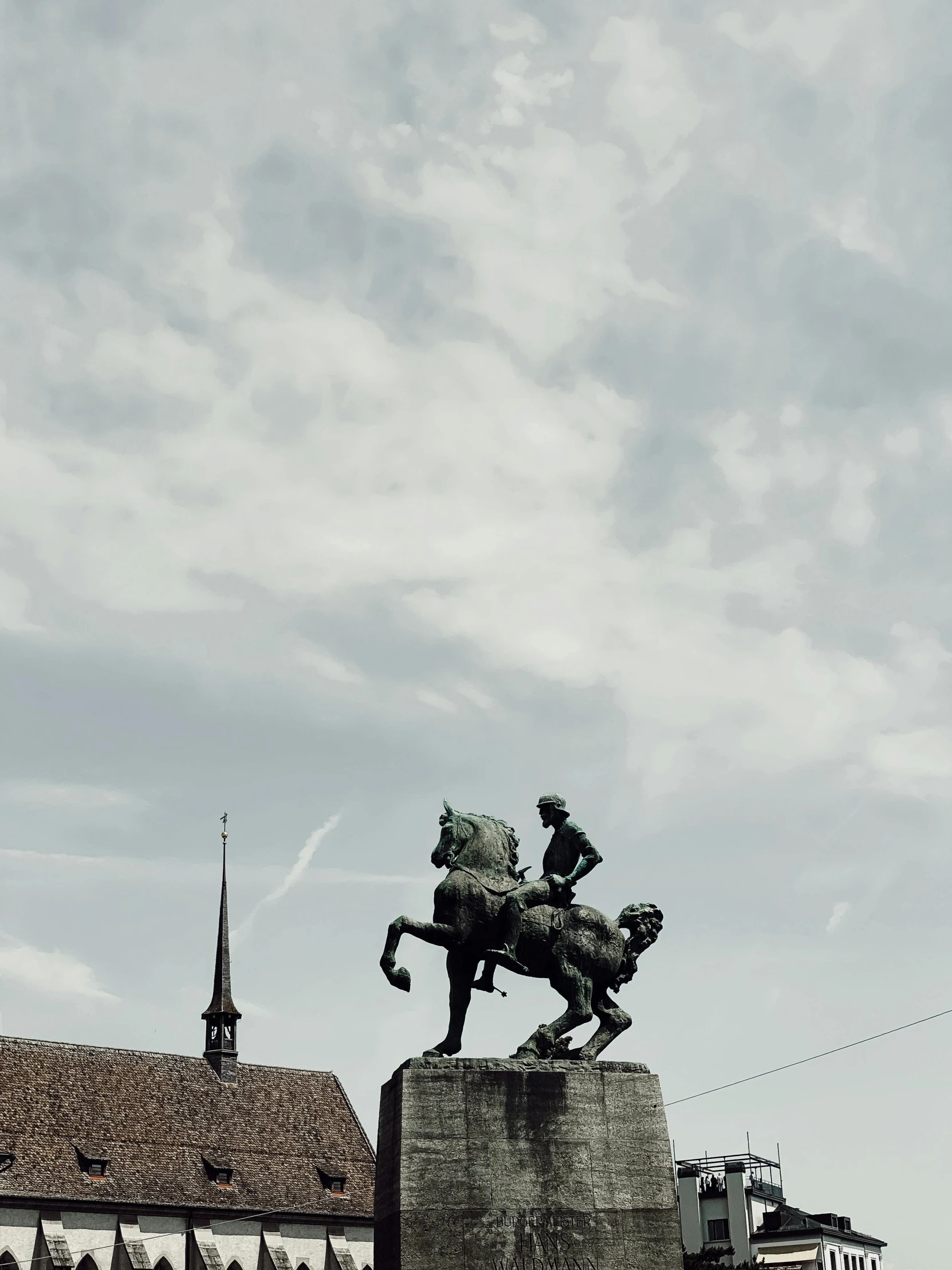 a statue is displayed in front of the city's buildings