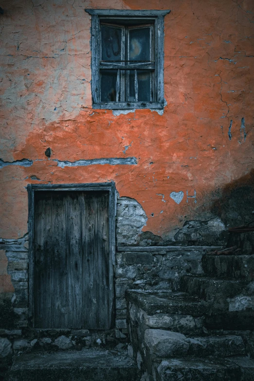 a wooden door sitting in front of a window on an orange wall