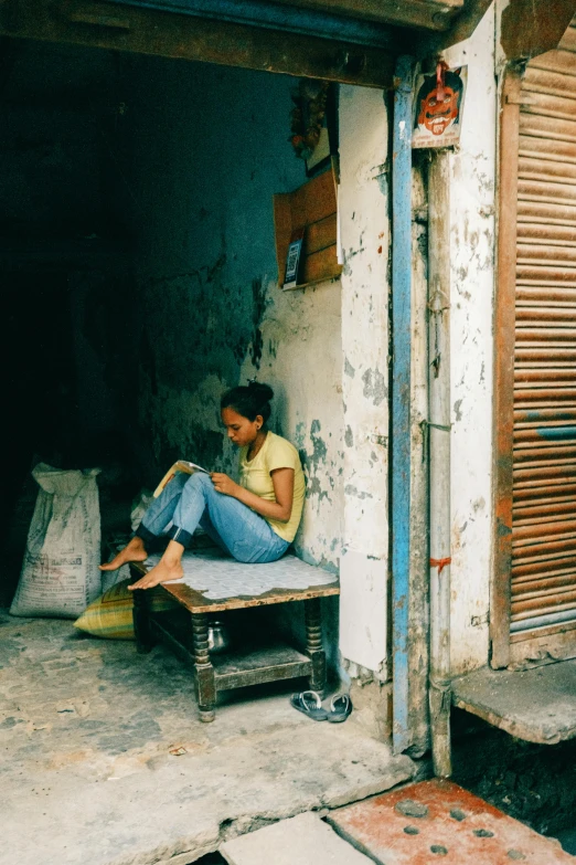 a woman is sitting outside by herself in her doorway